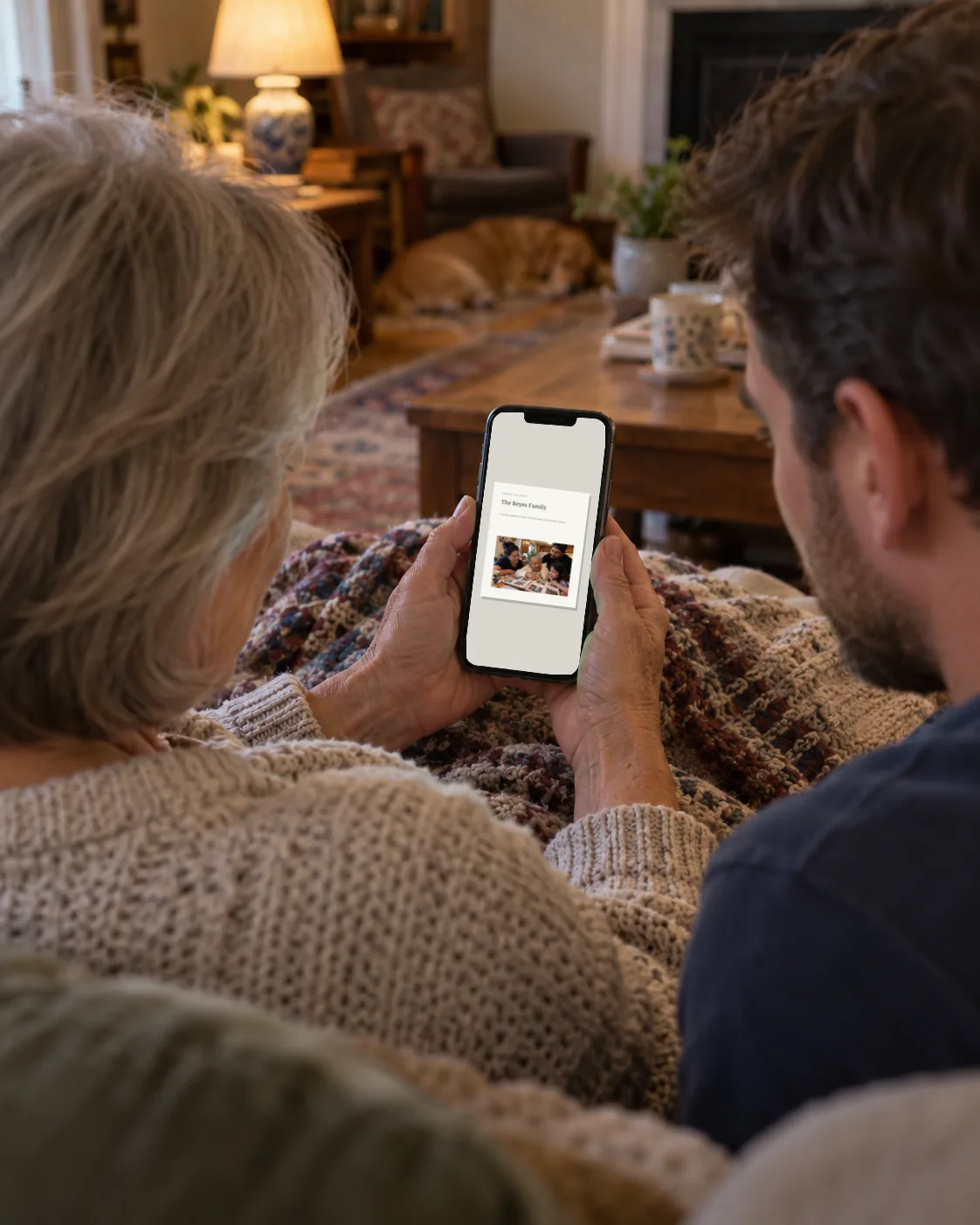 A mother and her adult son looking at the family book on her phone
